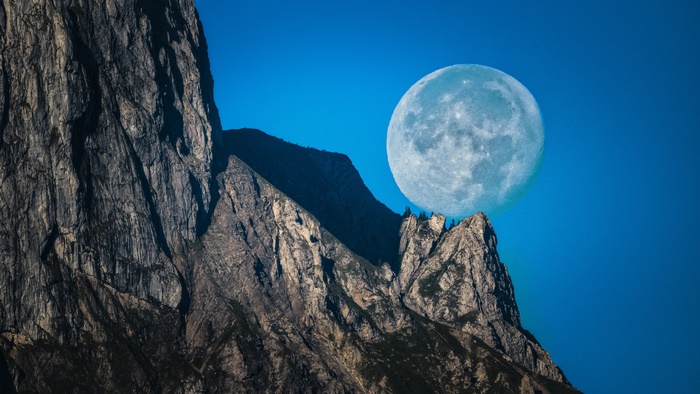Moon over rocky mountain peaks