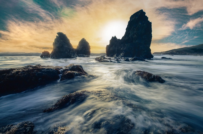 Seashore with rocks and waves at sunset 4K