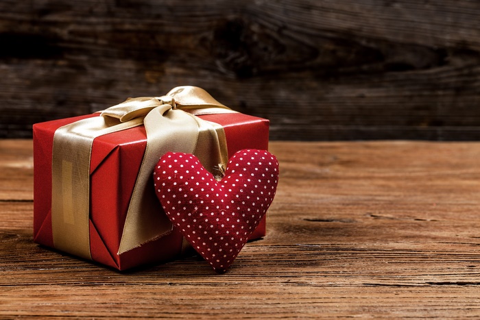 Red gift box with golden ribbon and polka dot heart