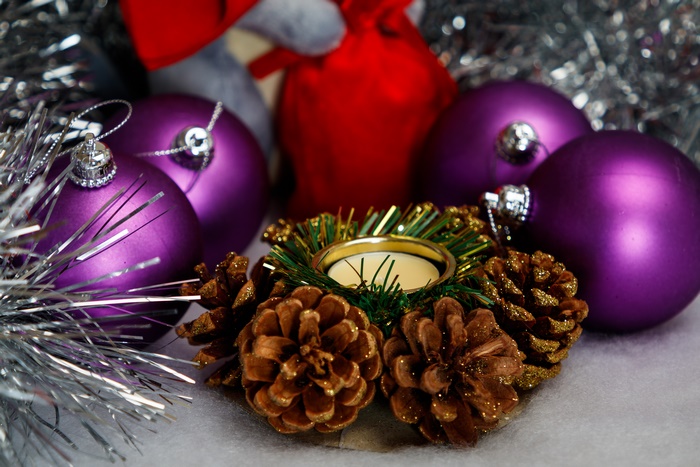 Christmas candle with pine cones and purple baubles