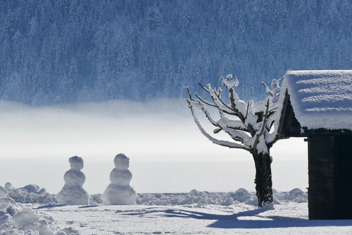 Snowmen and a cabin in a snowy landscape