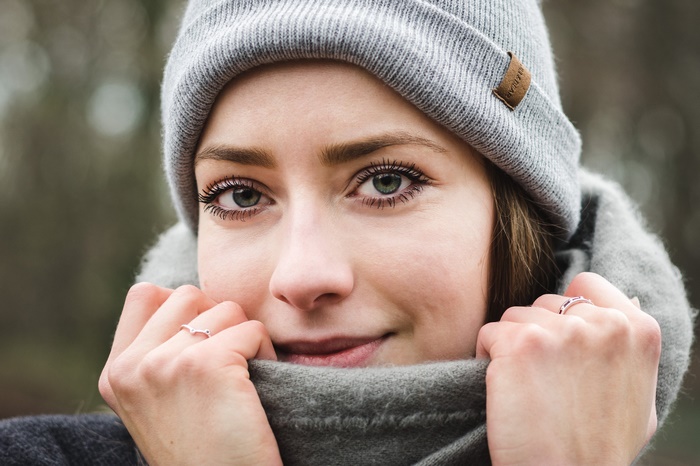 Woman wearing a grey beanie and scarf