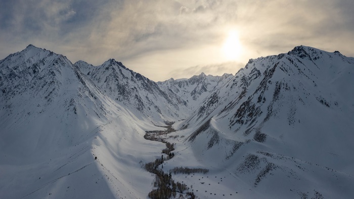 Winter Valley with Snow-Covered Mountains and Sun