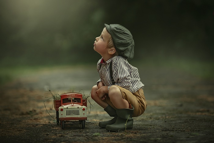 Boy in vintage clothes with toy truck