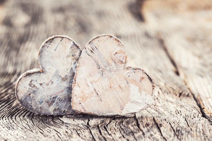 Two wooden hearts on a wooden surface