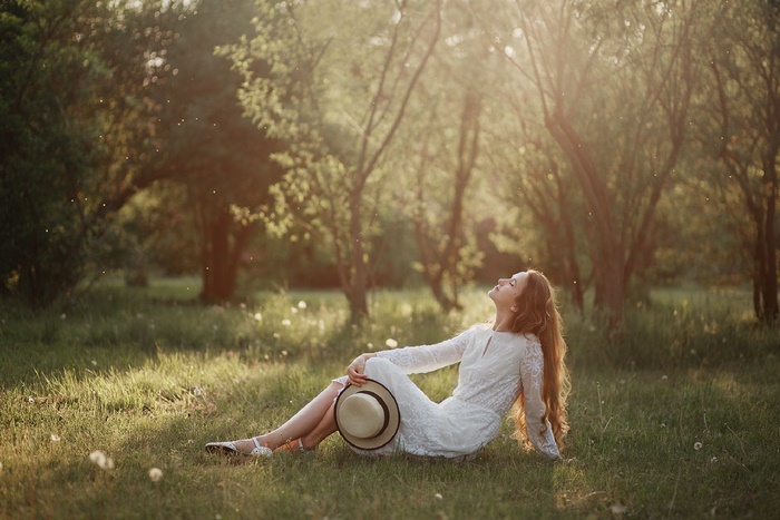 Woman in white dress with hat in a park