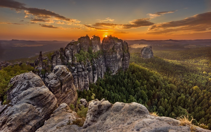 Sunset over rocky peaks and forest
