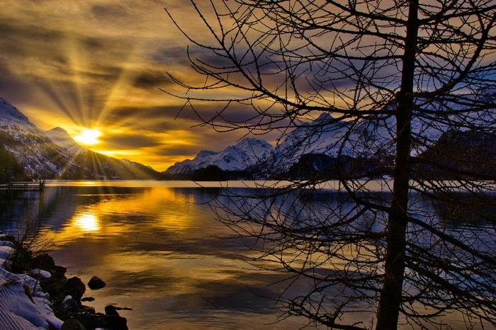 Sunset over a snowy mountain lake in Switzerland
