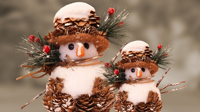 Two pine cone snowmen with festive decorations