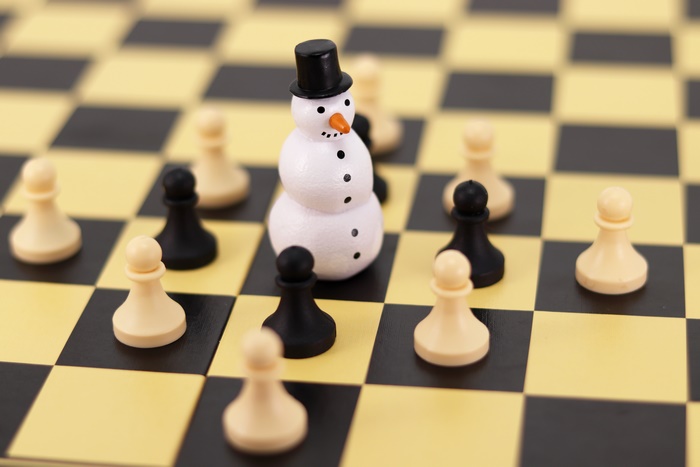 Chessboard with snowman and pawns