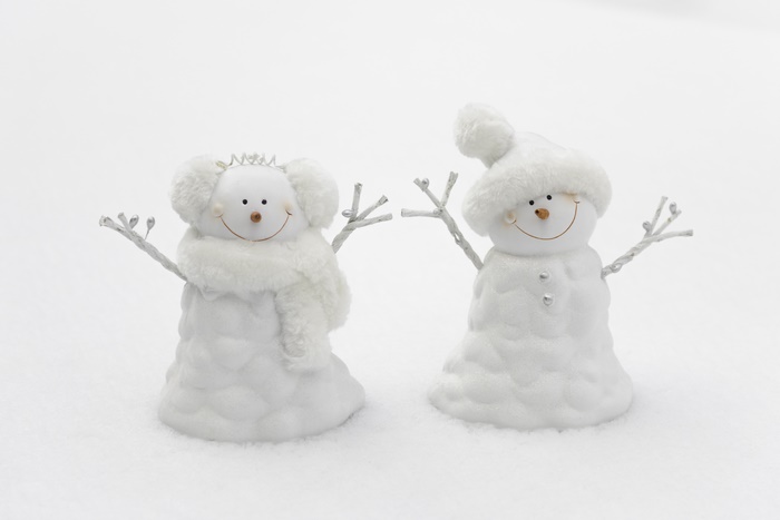 Two snowmen figurines in snow