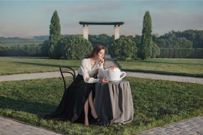 Woman with giant coffee cup in garden