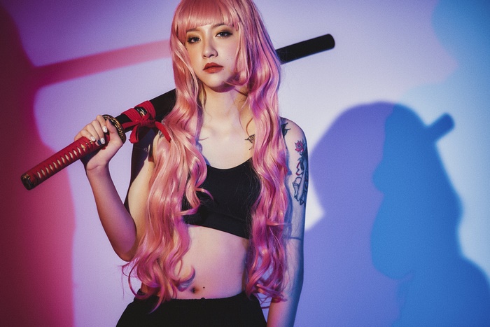 Woman with pink hair holding a katana