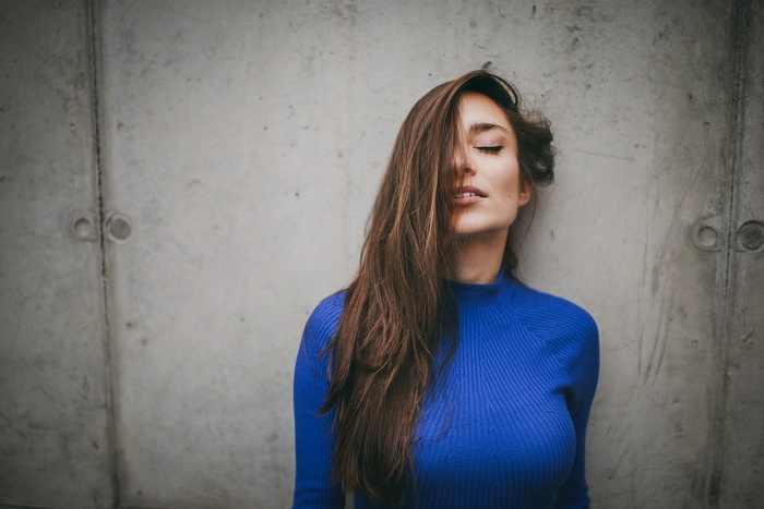 Woman with long brown hair in a blue sweater