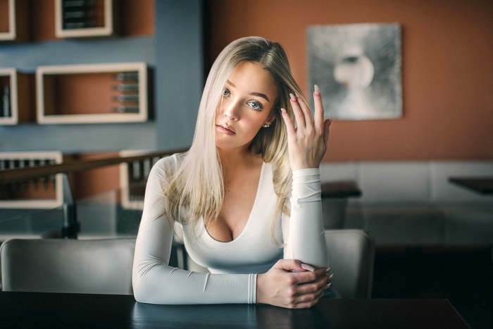 Blonde woman with blue eyes sitting at a table