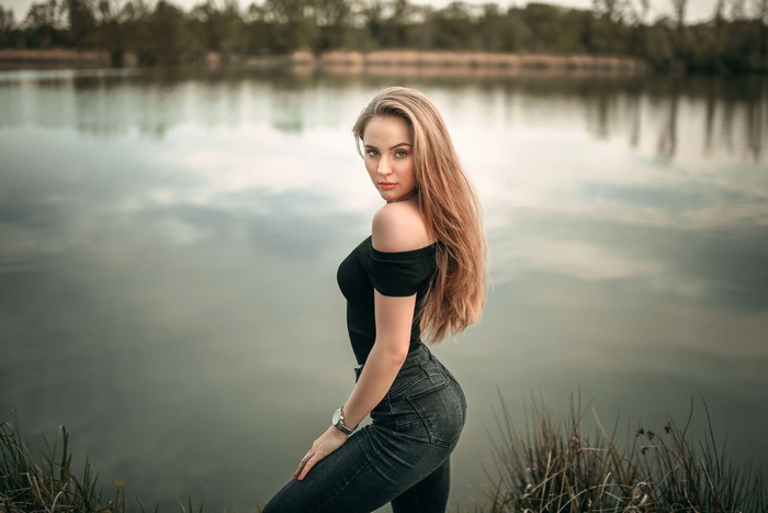 Woman with long blonde hair by a lake