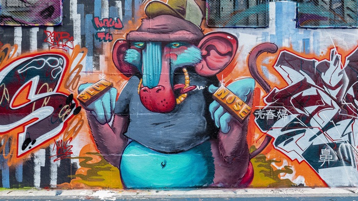 Graffiti of a baboon character holding gold bars