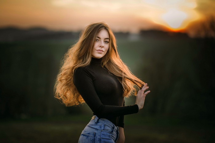 Woman with long hair in a black turtleneck and jeans