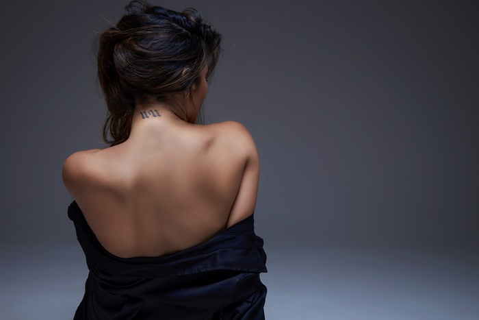 Woman with '11:11' tattoo on neck