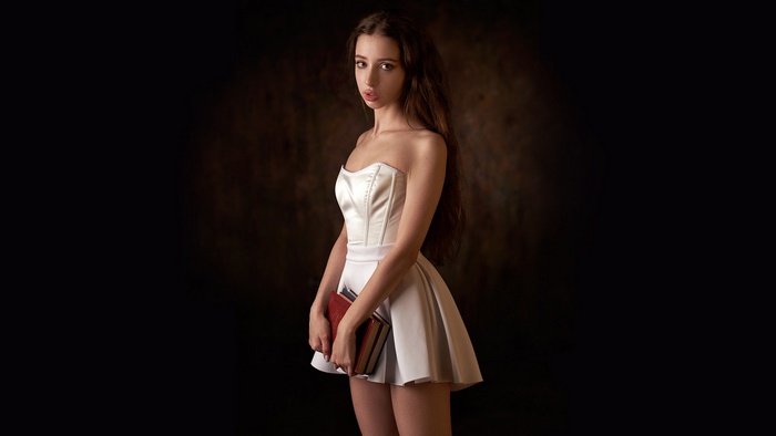 Woman in White Dress Holding Books