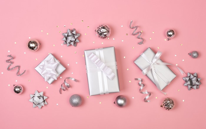 Christmas gifts and ornaments on pink background
