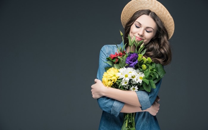 Woman in straw hat holding a bouquet of flowers