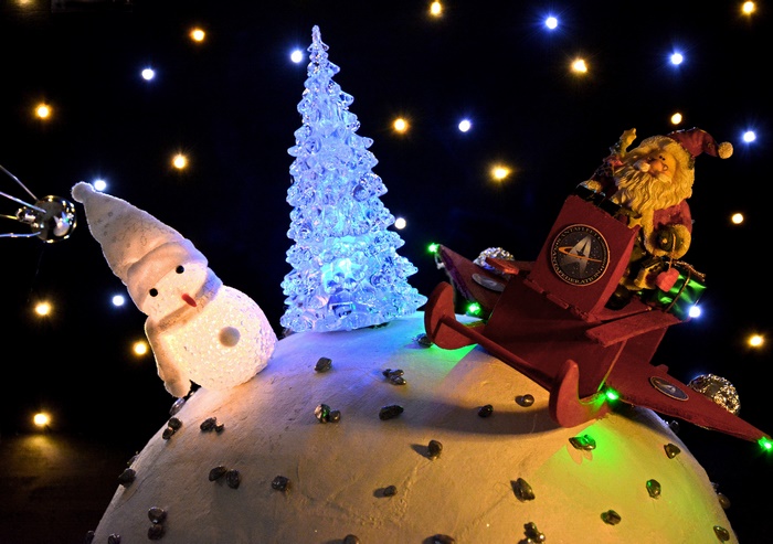 Santa and Snowman on a snowy planet with Christmas lights