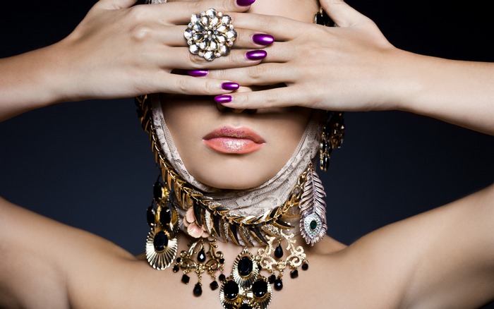 Woman with elaborate jewelry and purple nails