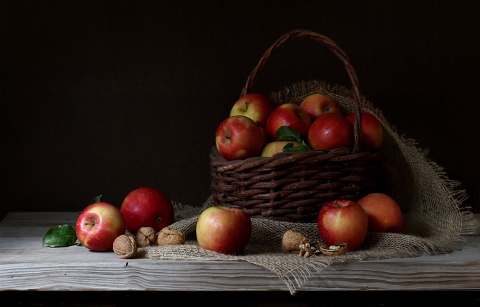 Still life with apples and walnuts in a basket