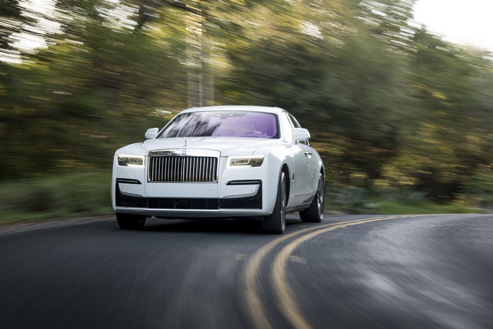 White Rolls-Royce Ghost driving on a road