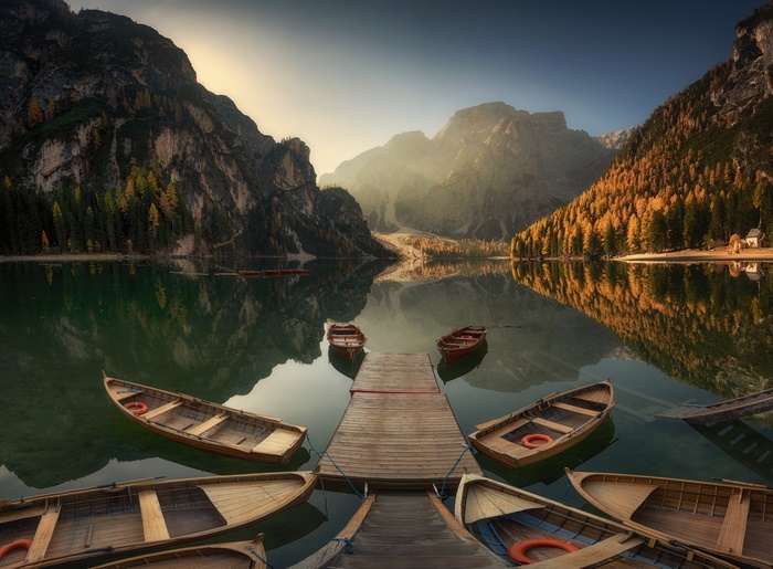 Boats docked at a wooden pier on a mountain lake