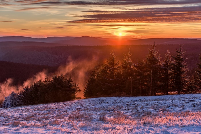 Winter Sunrise Over Forested Hills