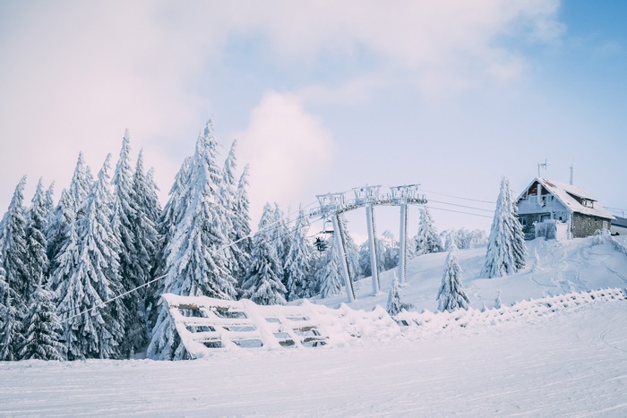 Ski lift and snow-covered fir trees on a mountain