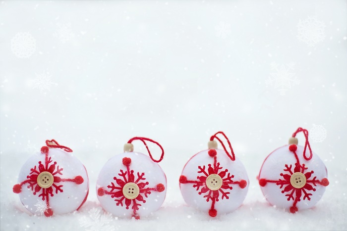 Four Christmas ornaments in snow
