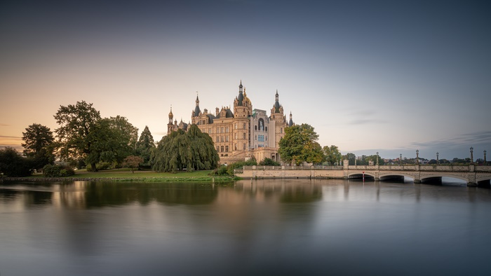 Schwerin Palace and bridge over a lake at sunset
