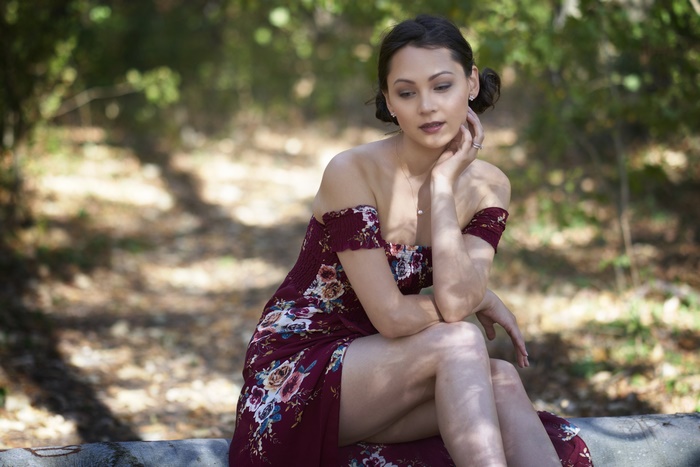 Model in a floral dress sitting outdoors