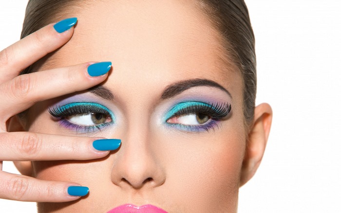 Woman with colorful eye makeup and blue nails