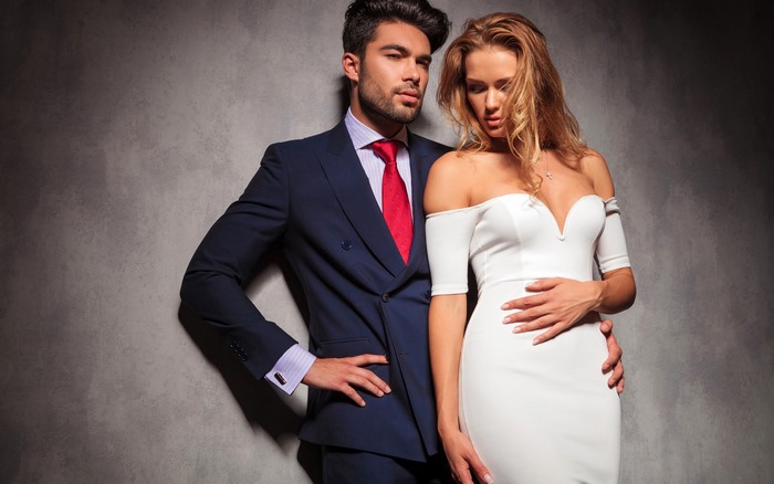 Man in Suit Embraces Woman in White Dress
