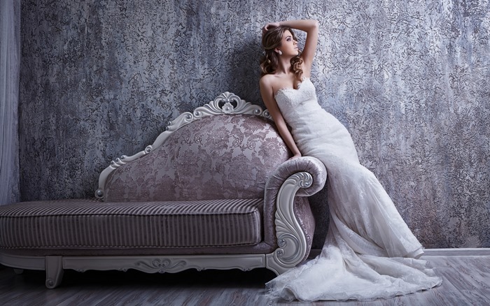 Bride in a white dress on a sofa