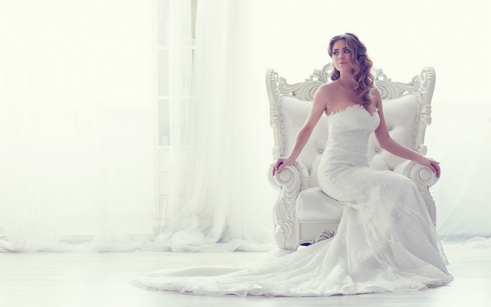 Bride in a white dress sitting on a chair