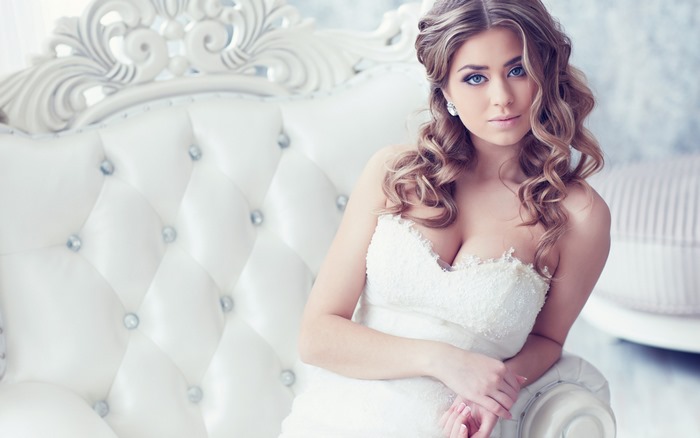 Bride in White Dress on a White Tufted Sofa