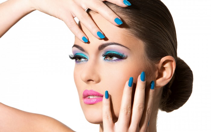 Woman with blue nails and vibrant makeup