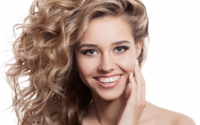 Model with beautiful curly blonde hair smiling