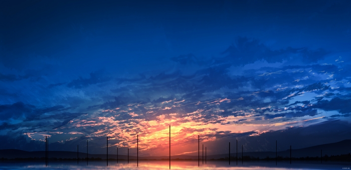 Sunset over a calm body of water with poles