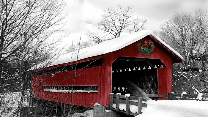Red covered bridge with snow and wreath