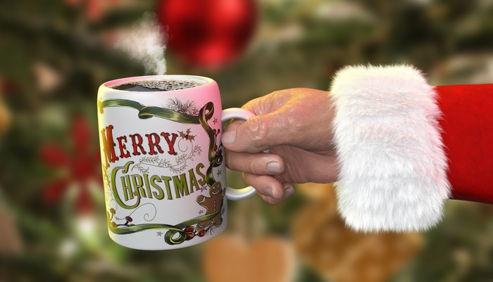 Santa holding a Merry Christmas mug with steam