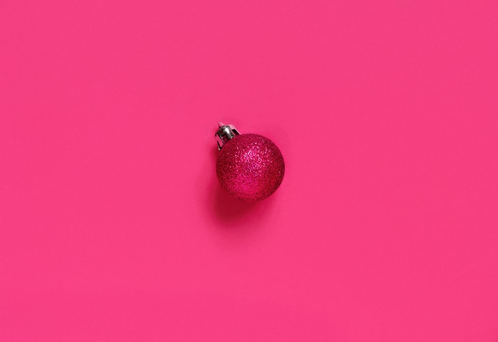 Pink glitter Christmas ornament on a pink background