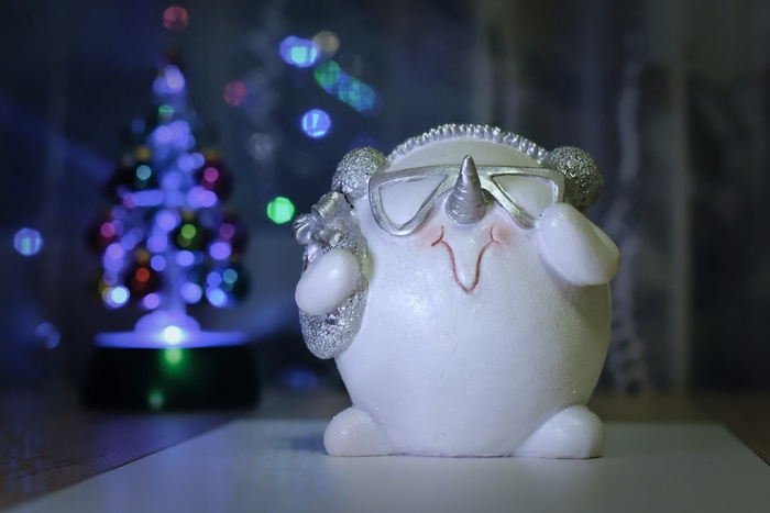 Christmas snowman figurine with unicorn horn and sunglasses