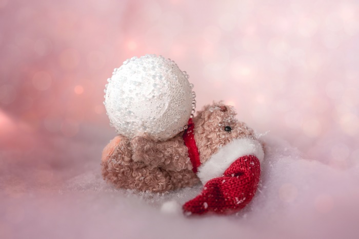 Teddy bear with Santa hat and snowball in snow