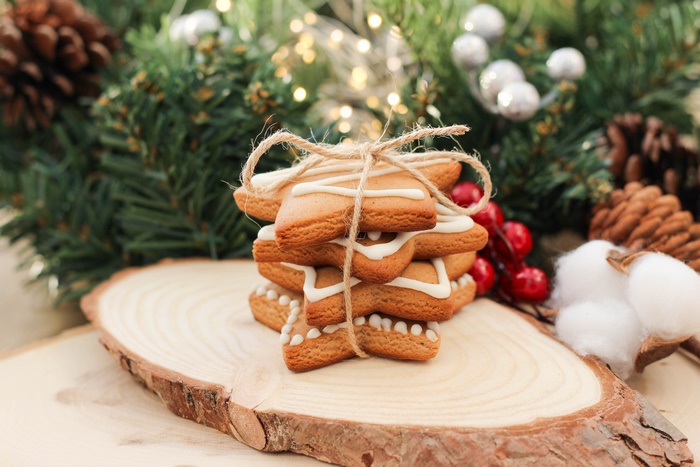 Christmas star cookies tied with twine on a wooden slice